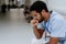 Young distressed doctor sitting at hospital corridor floor.