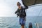 Young diver in a suit and diving equipment is preparing to jump from boat into the water