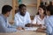 Young diverse colleagues gather in boardroom working on project