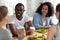 Young diverse friends sitting at table in cafe