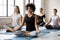 Young diverse people sitting in lotus pose during yoga session