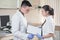 Young doctor and assistant standing and holding folder tablet