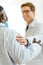 Young doctor in a lab coat congratulating colleague by patting him