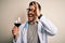Young doctor man wearing stethoscope drinking a glass of fresh wine over isolated background with happy face smiling doing ok sign