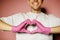 Young doctor in protective pink gloves showing heart symbol. Man in medical gloves gesturing love sign shape. Health care,