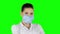 Young doctor putting on health mask. Green screen. Closeup