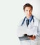 Young doctor with stethoscope and notepad against bright. Confident young doctor with stethoscope and notepad against
