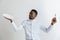 Young doubting attractive african american guy holding empty dish and fork isolated on grey background. Copy space and