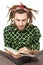 Young dreadlock man reading book isolated