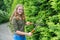 Young dutch woman pruning hedge with hedge trimmer