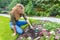 Young dutch woman raking in garden