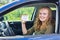 Young dutch woman showing card driving license in car