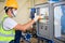 Young electrical engineer wearing a mask Inspect the electrical control cabinet and electrical control system in the building and