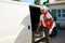 Young electrician artisan taking tools out of professional truck van