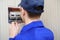 Young electrician in blue overall disassembling a electrical panel