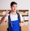 Young electrician with cable working in office