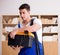 Young electrician with cable working in office