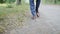 A young elegant businessman in brown shoes and blue pants is walking along the forest path