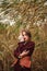 Young elegant lady on background of a reed field, portrait of fashionable girl posing in nature