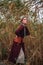 Young elegant lady on background of a reed field, portrait of fashionable girl posing in nature