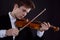 Young elegant male violinist violinist plays classical music on the violin.