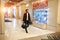 Young elegant man in fashion clothes walking in hotel with bag