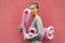 Young elegant woman holds the inflated word LOVE on a pink background