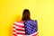 Young embarrassed woman covers herself with an American flag to maintain privacy and protect herself from abuse