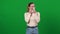 Young emotional Caucasian woman crying wiping tears with tissue. Portrait of young lady on green screen expressing