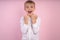 Young emotional handsome boy standing on pink studio background. Human emotions, facial expression concept