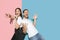 Young emotional man and woman on pink and blue background