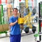 Young employee in a company manufacturing safety glass for house construction - works with a lifting tool