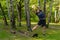 A young enduring athletic athlete is doing stretching in the forest outdoors, around the forest, oak trees.active nature