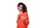 young energetic positive caucasian lady with black curly hair is dressed in an orange shirt on a white background