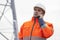 Young engineer or foreman talking  on smart phone on a oil platform or construction site