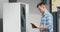 A young engineer sets up a heat pump near a private house. Uses a tablet