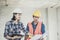 Young engineer women and worker looking at blueprint and planning the construction indoor working site