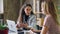 Young enterpreneur is talking to her partner in modern office while sitting at desk together. Women are planning new