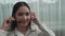 Young enthusiastic female customer support operator put on headphone.