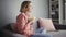 Young enthusiastic woman sitting on the sofa, eating popcorn and watching TV