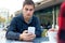 Young entrepreneur using his mobile phone at coffee shop.