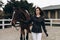 A young equestrian in uniform poses with a beautiful, majestic horse.