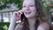 Young European business woman talking on the phone outside an office building. Cheerful girl dressed in formal clothes