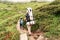 A young European family of tourists, a father with heavy backpack and a young son waiking on the mountain trails.