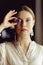 Young european girl holding a gemstone in hand in front of her. Looking towards the camera. Mystical woman..