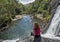 Young european tourist woman sitting on the edge of the Baker`s falls in the national park