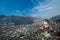 Young european woman sitting among trash at the garbage dump with truck passing by