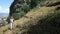 Young European woman walks down hill with hiking poles against backdrop of town of Fethiye in Turkey.