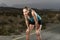 Young exhausted sport woman running outdoors on asphalt road stop for breathing tired