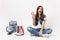 Young exited woman student with opened mouth holding plastic cup of soda or cola sitting near globe, backpack, school